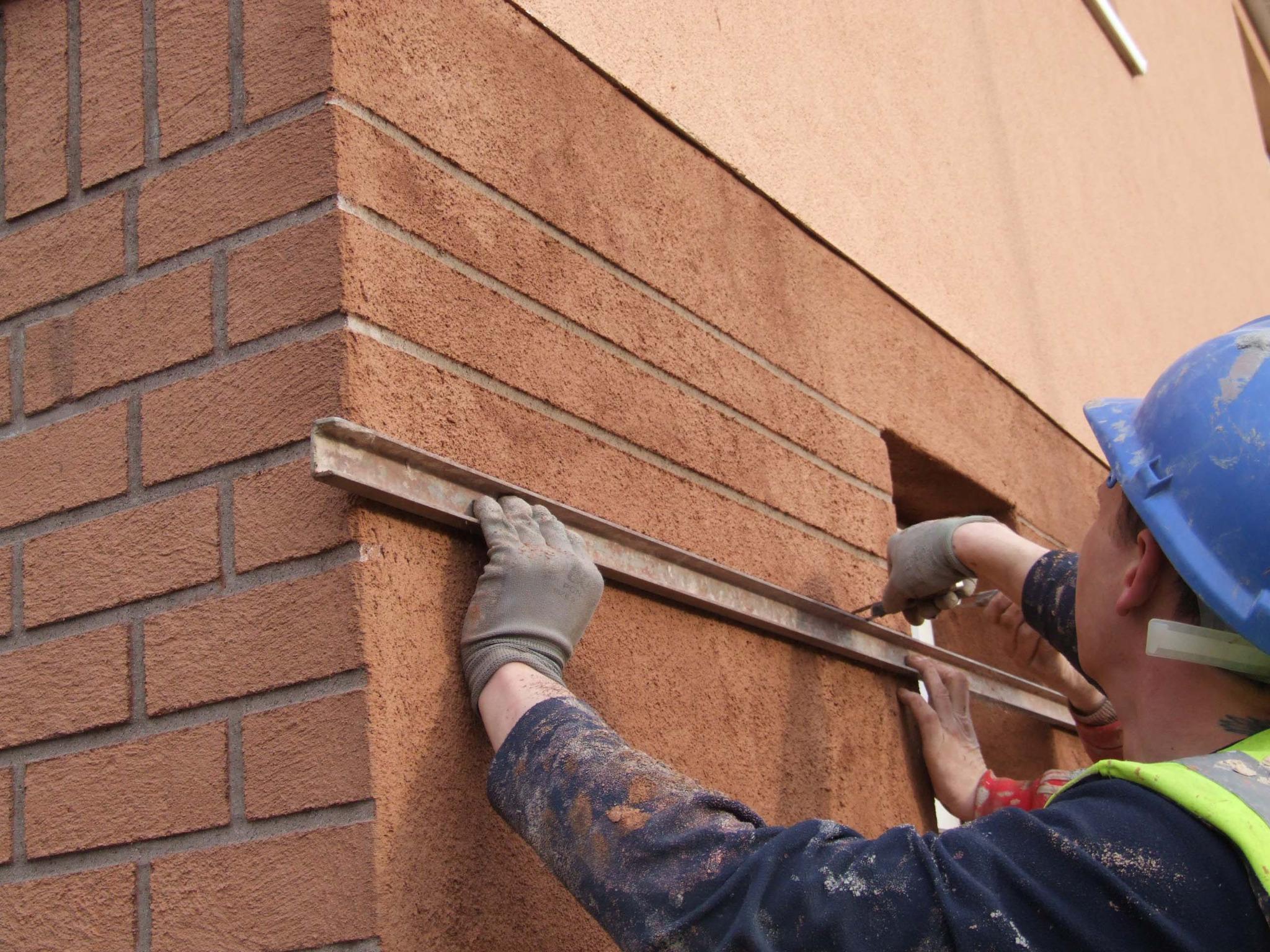 Brick effect render being finished with a hand trowel